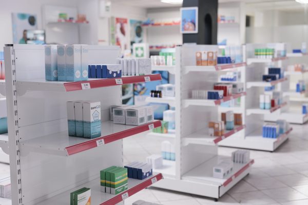 Empty drugstore with bottles and packages full with medicaments, retail shop shelves with pharmaceutical products. Pharmacy space filled with medical drugs and pills, vitamins boxes.